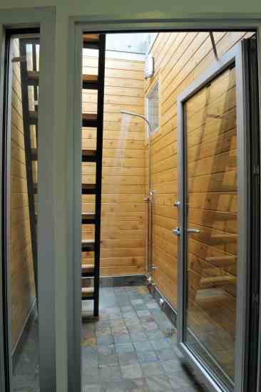 
A wood-walled outdoor shower with recycled glass tiles lends a spa-like quality.
